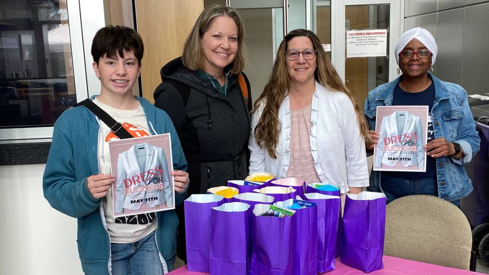 Roby, from Denver, Colorado,o stands with their mother and representatives from Dress for Success with the bags he created to support Dess for Success