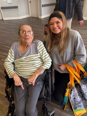 Lauren visiting a retirement home resident with goody bags