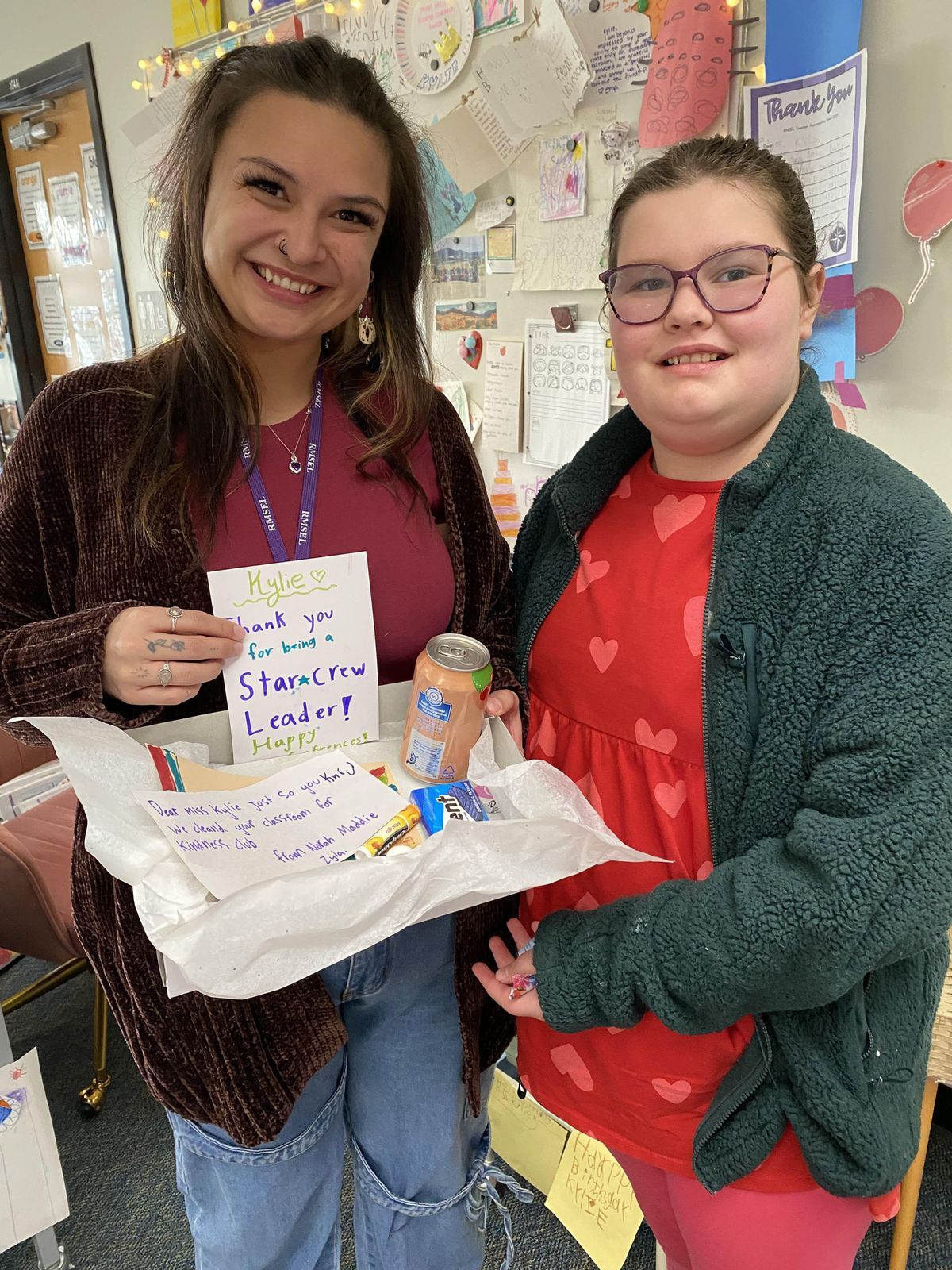 Frances handing a teacher break kit to a kindergarten teacher during conference week