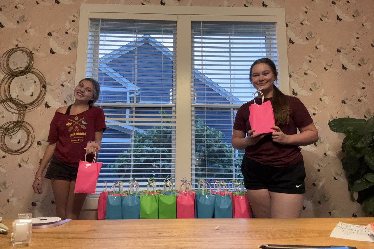 Carys and Aubrey with the finished teacher gift bags lined up on the table