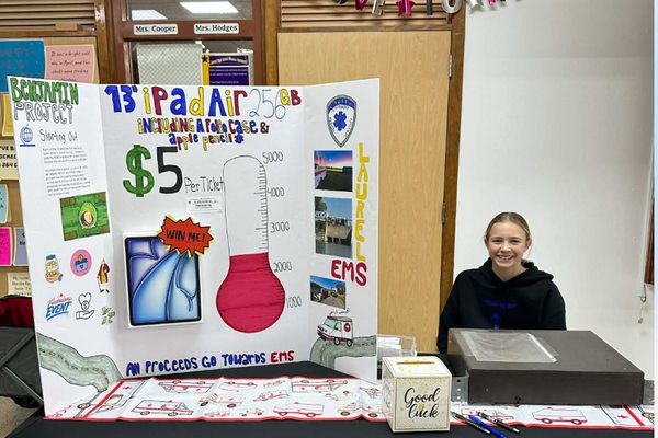Claire selling raffle tickets at her booth during a local basketball game