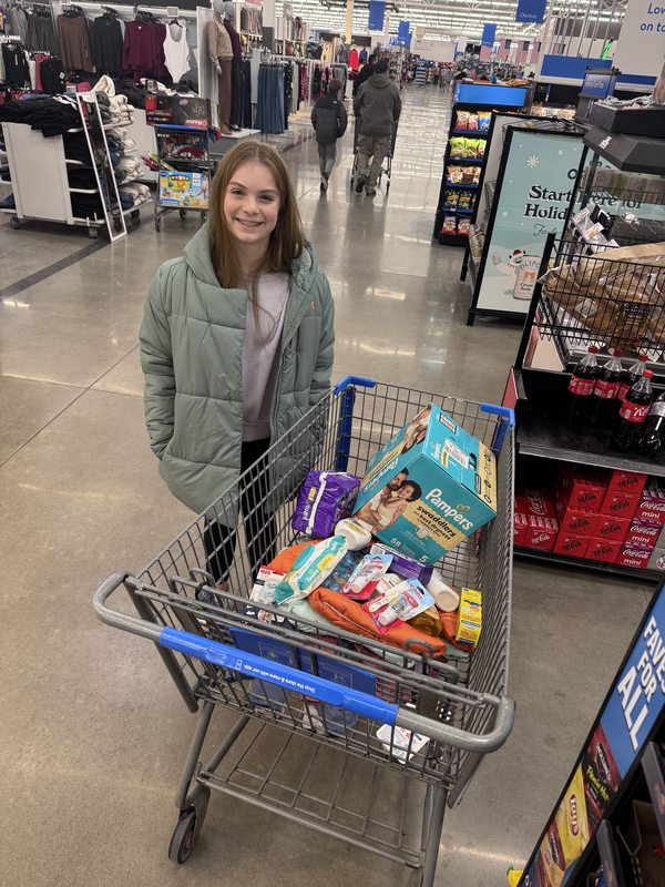 McKenzie at Walmart with a shopping cart filled with diapers and other baby supplies