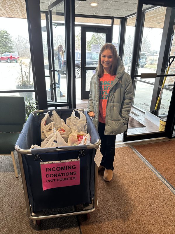 McKenzie delivering bags of supplies to the incoming donations bin at Kaitlyn's Kloset