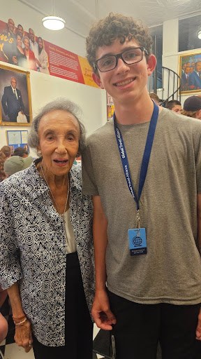 A student standing with an elderly woman during his travel scholarship trip to Washington, D.C.